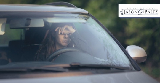 girl resting head on hand in drivers seat of car