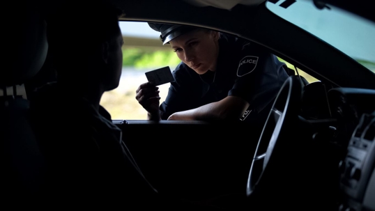 Driver pulled over and an officer looking at the driver's license