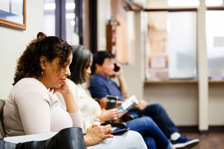 Three people sitting in a doctor's office waiting room