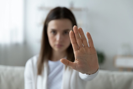 Woman holding her hand up to symbolize stopping an assault