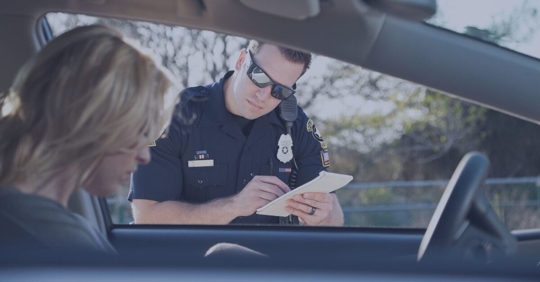 man at window police writing ticket